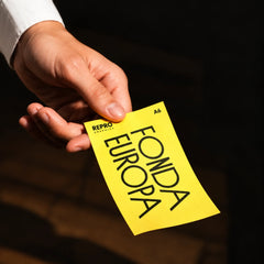 A6 flyer held in hand, yellow printed design